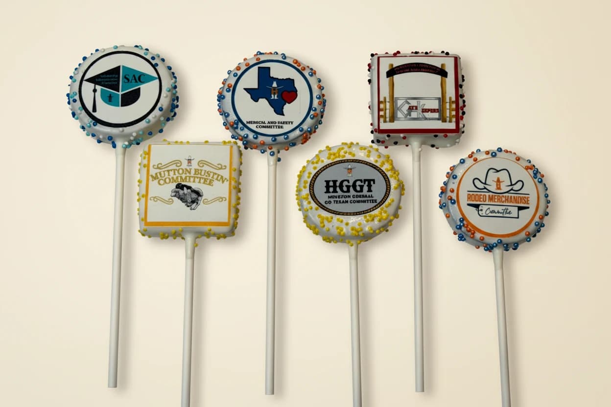 Cake pops with printed Texas committee, rodeo, and graduation logos.